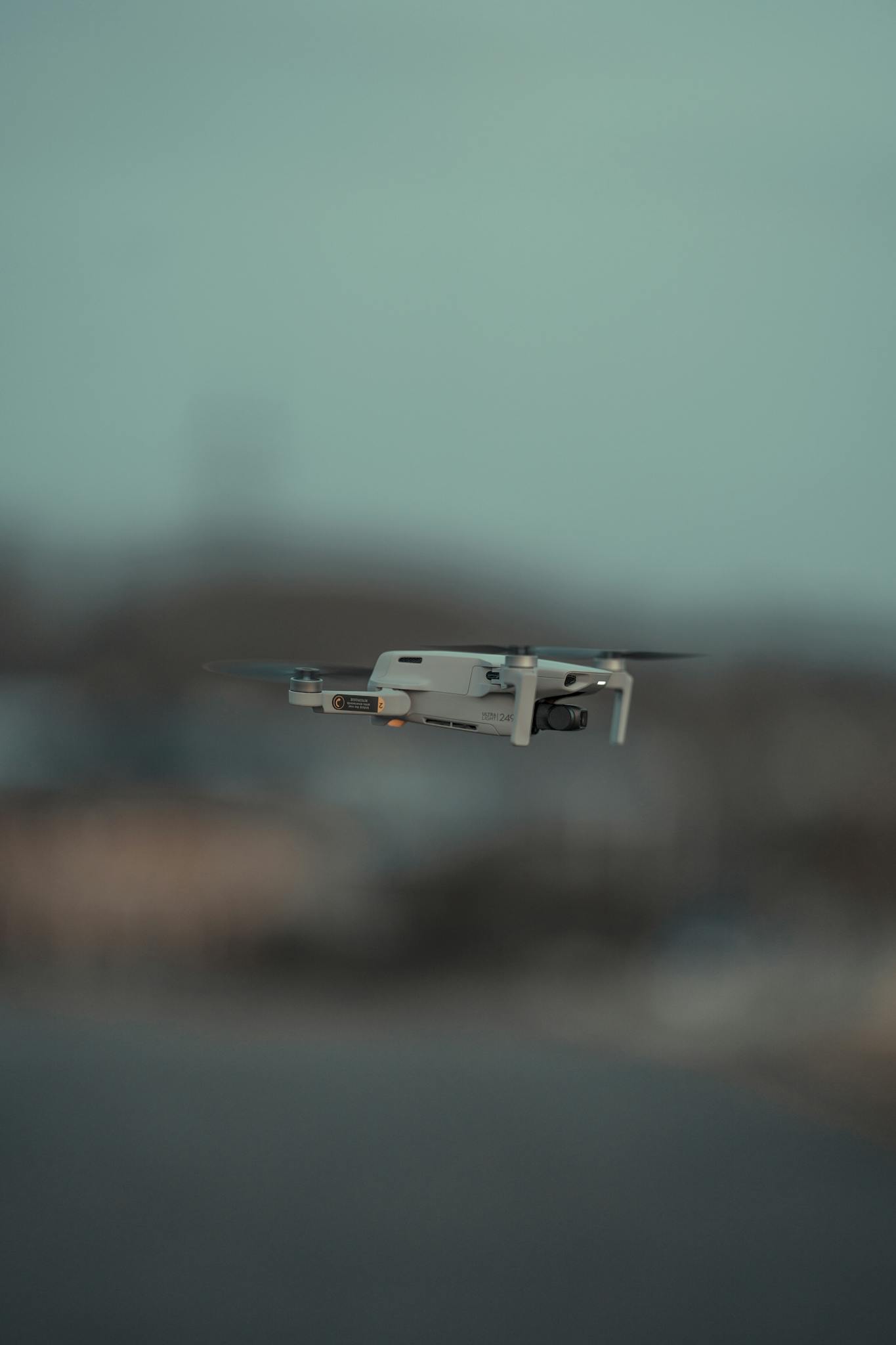 Modern drone flying with shallow focus against a blurred backdrop, showcasing cutting-edge technology.